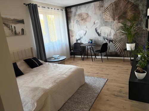 a bedroom with a bed and a wall with birds at Apartament Żurawie in Jastrowie