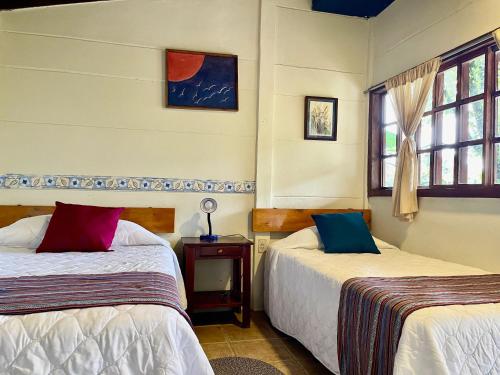 a bedroom with two beds and a window at cabañas de Apaneca in Apaneca