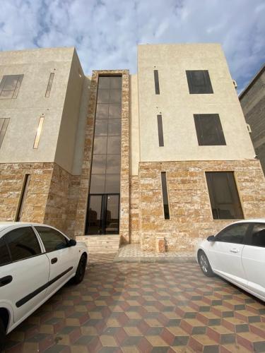 two white cars parked in front of a building at الضاحية 