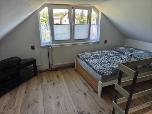 a bedroom with a bed and two windows at Chata Rumunka in Jaroměř