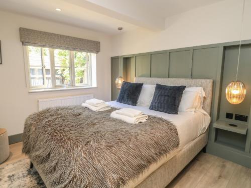 a bedroom with a large bed with towels on it at 12 Manor Farm Close in Kingham