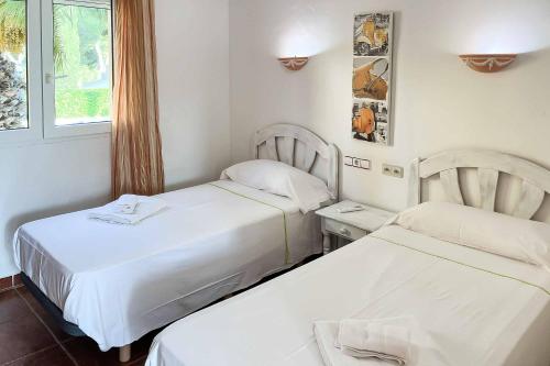 a hotel room with two beds and a window at Villa Nispero in El Tosalet