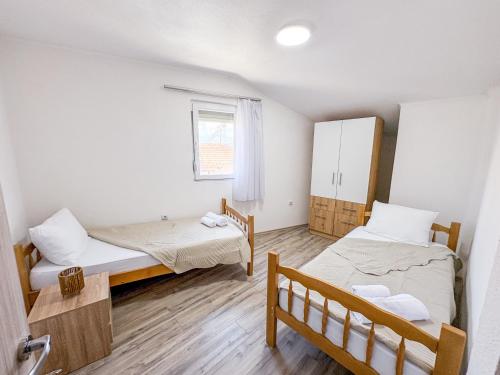 a small room with two beds and a window at Muso Apartments in Gevgelija