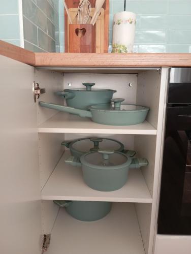 a cupboard filled with pots and pans at Kawalerka pod lasem in Poddębice