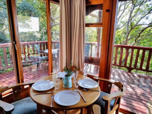 a wooden table and chairs on a porch at Forest Edge Hideaway -Six on Imbali in George