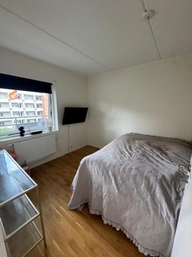 a white bedroom with a bed and a window at Modern apartment with large balcony in Halmstad