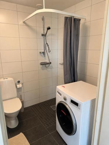 a washing machine in a bathroom with a toilet at Modern apartment with large balcony in Halmstad