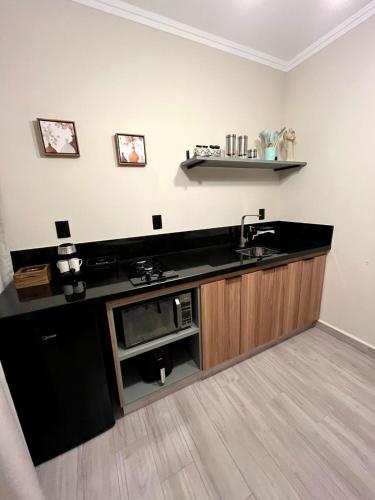 a kitchen with a sink and a microwave at Angatu Chalés in Serra Negra