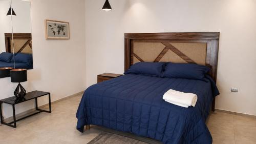 a bedroom with a blue bed with a wooden headboard at Suite privada con alberca - Cama Queen in El Centenario