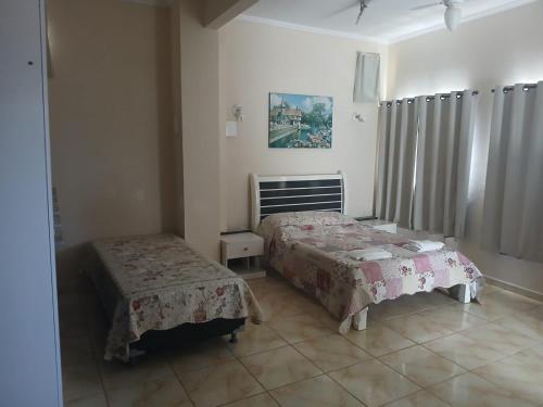 a bedroom with two beds in a room at Pousada Narcizo in São Lourenço