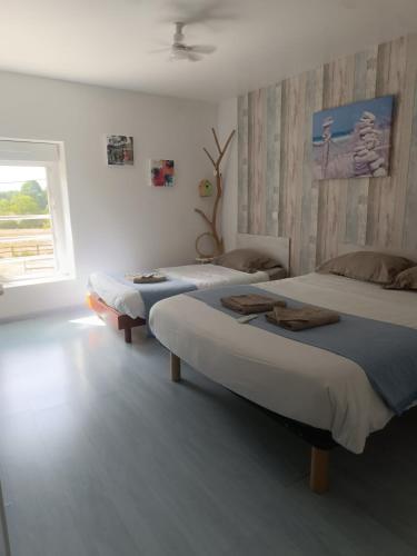 a bedroom with two beds and a window at Les Mesanges in Combrand