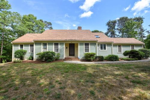 a white house with a roof on a yard at 1 6 mi to Nauset Beach in Orleans