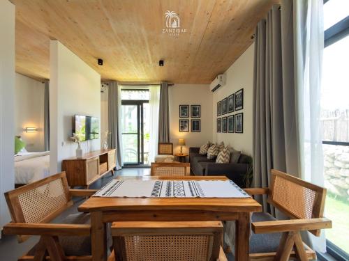 a living room with a wooden table and chairs at Zanzibar Stays Accommodation Collection, The Soul, Paje in Paje