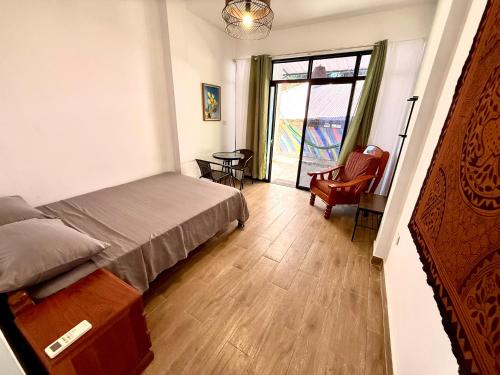 a bedroom with a bed and a chair and a window at Chaikoni Lodge in Pucallpa