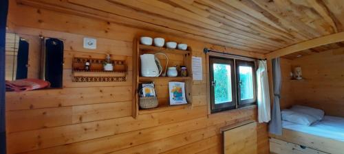 a wooden cabin with a bed and a window at Une roulotte dans les vignes Ancenis in Vallons-de-l'Erdre