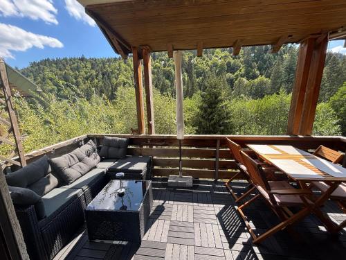 a screened in porch with a couch and a table at Ferienwohnung Tannenhöh in Todtmoos