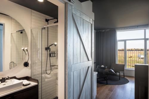 a bathroom with a shower and a sink at Hôtel & Spa Le Germain Charlevoix in Baie-Saint-Paul