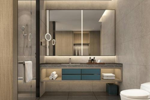 a bathroom with a sink and a mirror at Courtyard by Marriott Rizhao in Rizhao