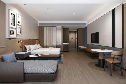 a hotel room with a bed and a living room at Four Points by Sheraton Fuzhou Changle in Fuzhou