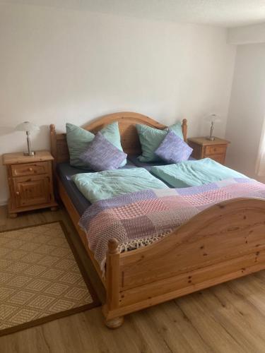 a wooden bed with pillows on it in a bedroom at Ferienwohnung Loni in Kulmbach