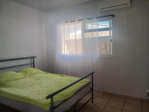 a bedroom with a bed and a window at Jambolana Studio in Punaauia