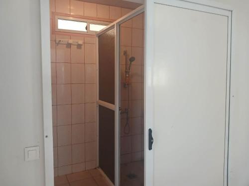 a shower with a glass door in a bathroom at Jambolana Studio in Punaauia