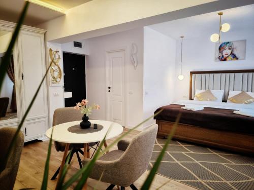 a hotel room with a bed and a table and chairs at Verso Studio in Curtea de Argeş