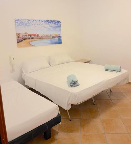 two beds in a room with a painting on the wall at Cuttin Apartment in Gallipoli