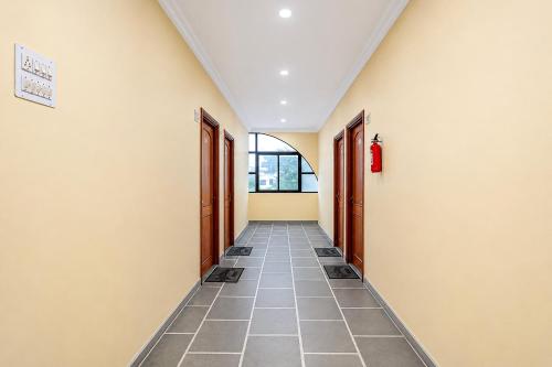 a hallway with doors and a tile floor at SPOT ON Hotel Silver Spoon in Dhule