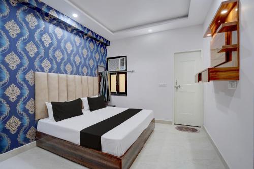 a bedroom with a bed and a blue and white wall at Hotel O Rooftop Inn in New Delhi