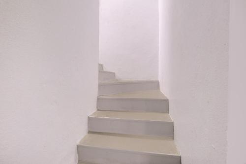 a staircase in a white room with white walls at SPOT ON Hotel Silver Spoon in Dhule