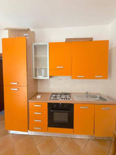 a kitchen with orange cabinets and a stove top oven at Cuttin Apartment in Gallipoli
