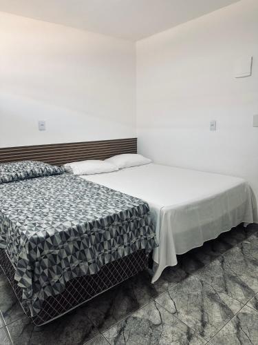 two beds in a room with white walls at FRAN's - HOSPEDAGENS in Lagoa Santa