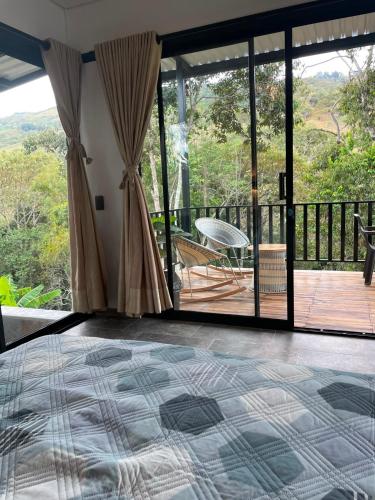 a bedroom with a bed and a balcony at Villa Milú Refugio boutique in Guaduas