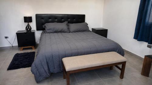 a bedroom with a large bed with a blue comforter at Loft privado con alberca - Cama King in El Centenario