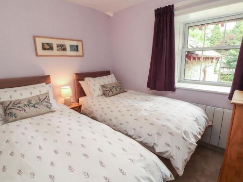 a bedroom with two beds and a window at East View in Kirkby Stephen
