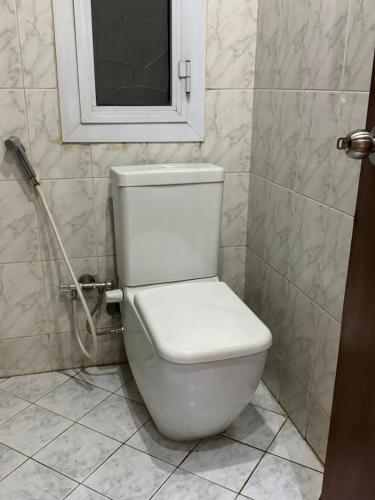 a white toilet in a bathroom with a window at Verssailles Al Manar Hotel in Cairo