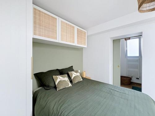 a bedroom with a large bed with white walls at Le Cosy Garibaldi in Sotteville-lès-Rouen