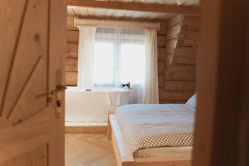 a bedroom with a bed and a window at Willa Madejówka - Apartamenty z Widokiem na Góry i Wanną z Jacuzzi in Ząb