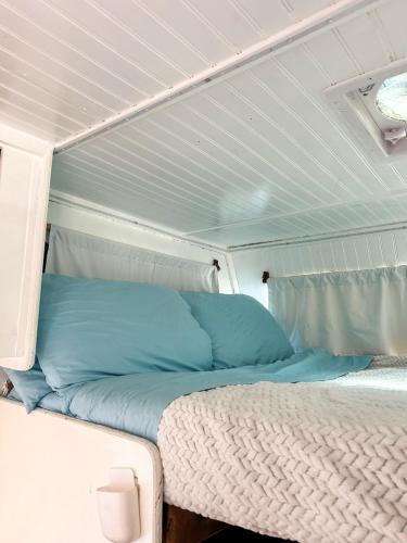 a bed with blue pillows in a room at Cozy & Private Tiny House Style in Hickson