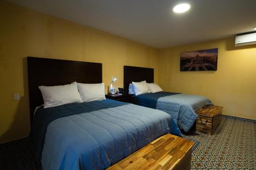 a hotel room with two beds with blue sheets at Kali Doña Tere in Acámbaro