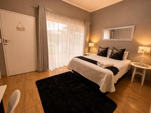 a bedroom with a large bed and a window at Zhantique Guest House 2- Unit 5 in Boksburg