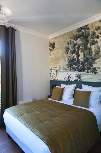 a bedroom with a large bed with a painting on the wall at Maison Constant - Le Camélia in Autun