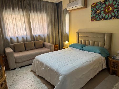 a bedroom with a large bed and a couch at Appartement Wassim - Gueliz in Marrakesh