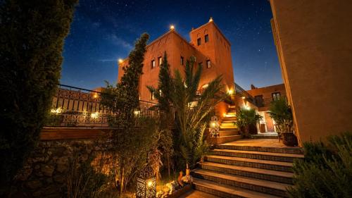 a building with stairs in front of it at night at Riad Ouinz in Aït Benhaddou