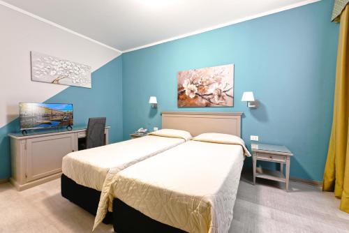 a bedroom with a bed and a blue wall at Hotel Bristol in Trieste