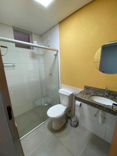 a bathroom with a toilet and a shower and a sink at Hotel Grajaú in Arcos