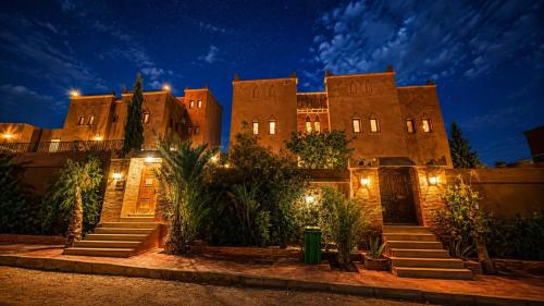 a building with stairs in front of it at night at Riad Ouinz in Aït Benhaddou