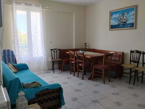 a living room with a couch and a table and chairs at Waves and Wonders Apartment in Korthi