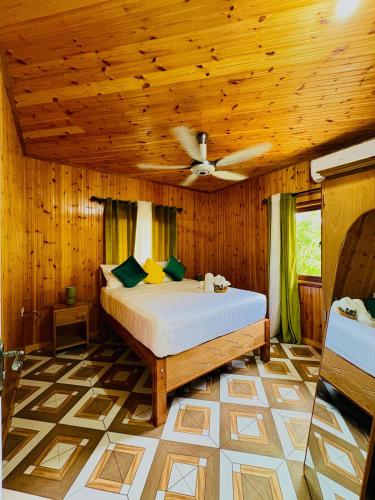 a bedroom with a bed with a wooden ceiling at La Vue De Mer in La Digue